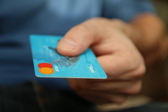 Ein Mann hält eine Paysafecard in seiner Hand