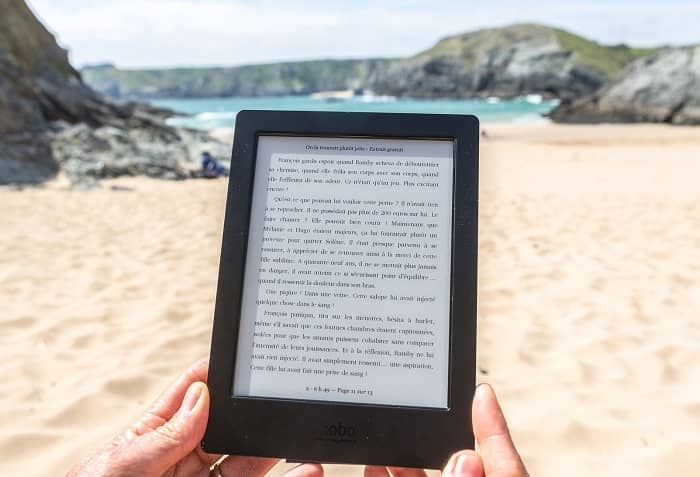 Eine Frau liest am Strand mit Ihrem E-Book