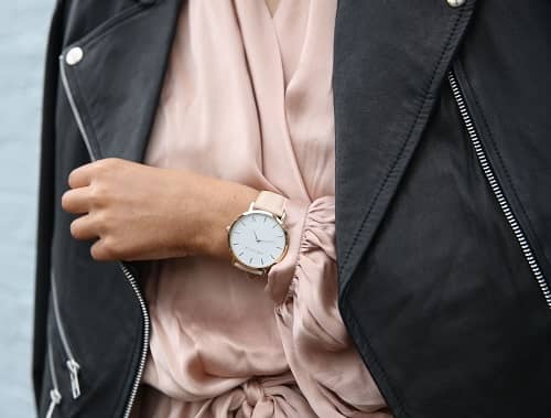 Eine Frau die sehr schick angezogen ist und eine modische Armbanduhr trägt