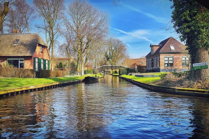 Ein Kanal, an dem beiderseits schöne Gärten mit prächtigen Häusern zu sehen sind