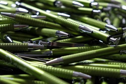 Eine Menge grüner Kugelschreiber liegen durcheinander auf einem Berg