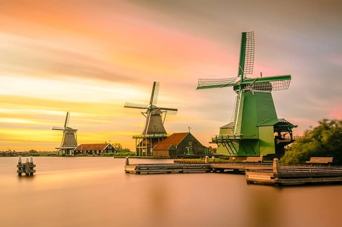 Drei Große Windmühlen stehen an einem Wasser