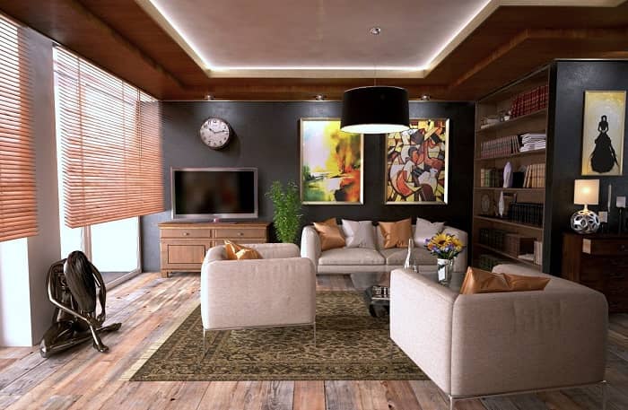 Ein Wohnzimmer mit großer Sitzgruppe und grauen Wänden mit großen bunten Bildern