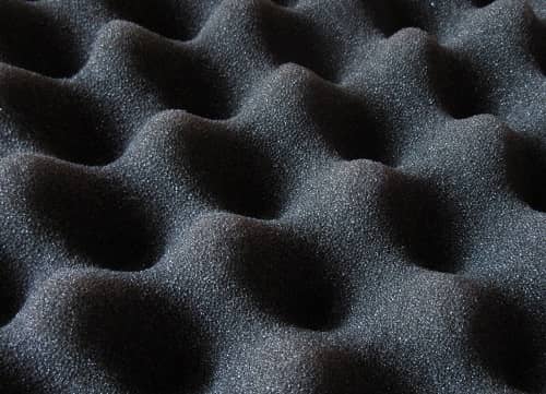 Ein schwarzer in Wellengeschnittener Akustikschaumstoff ist dargestellt