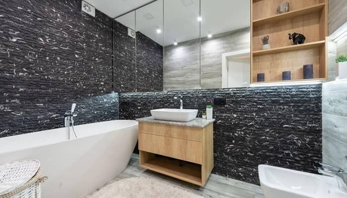 Badezimmer mit einem Badlüfter, frei stehender Badewanne und schwarz/weißen Wänden