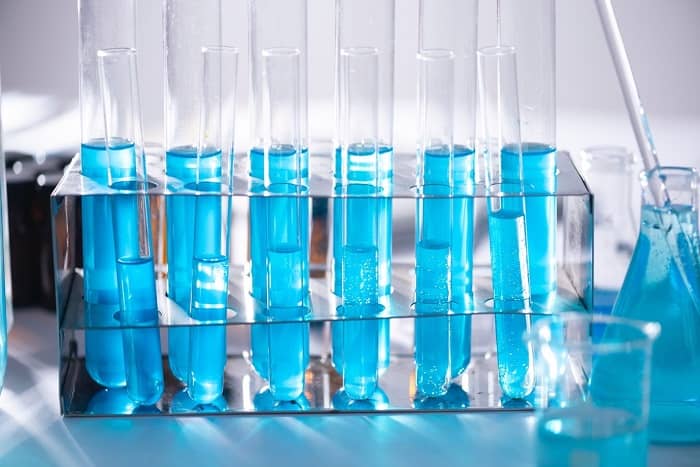 Reagenzgläser mit blauer Flüssigkeit stehen auf einem Tisch
