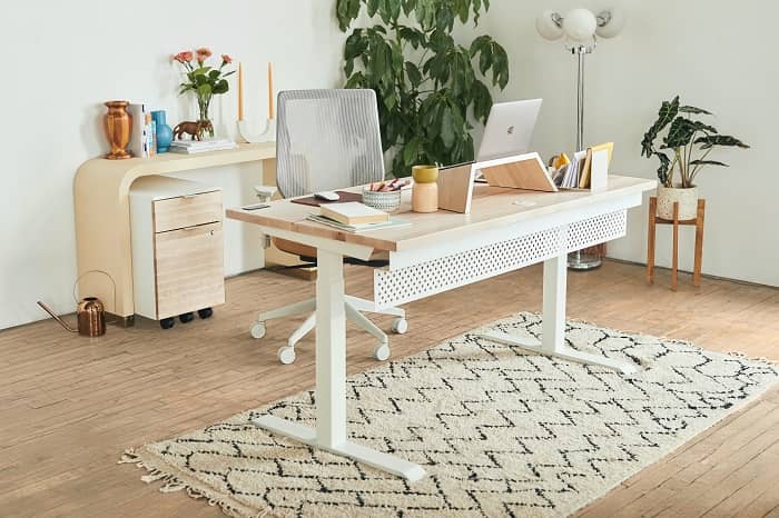 Ein Home-Office in beigem Farbton, mit einem Schreibtisch und Laptop darauf