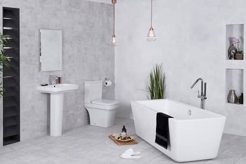 Ein geräumiges, in grau gehaltenes Badezimmer mit freistehender Badewanne, Waschbecken und Toilette