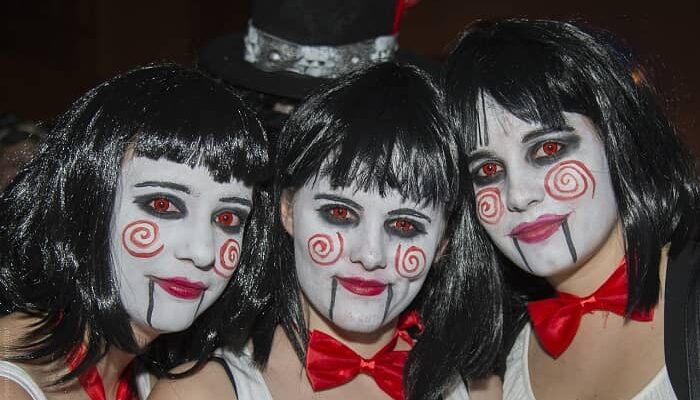 Drei geschminkte und maskierte Frauen lachen in die Kamera