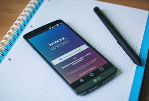 Ein Smartphone mit einem geöffneten Instagram Account liegt auf einem Notizblock
