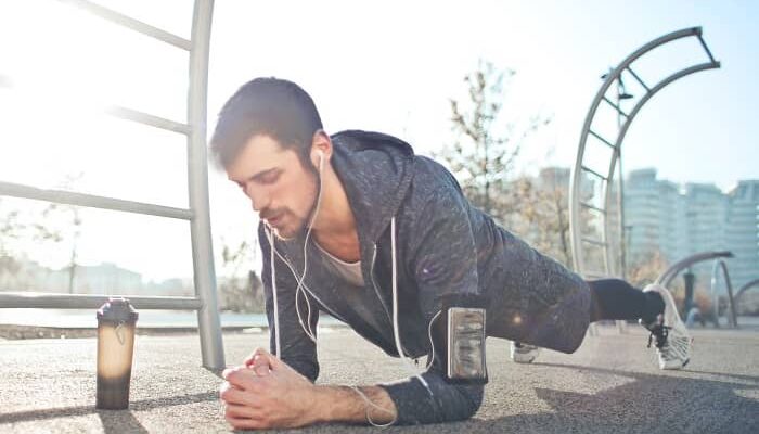 Ein Mann macht im Freien Planken als Sportübung um Muskeln zu stärken