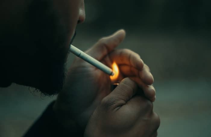 Ein Mann zündet sich eine Zigarette an