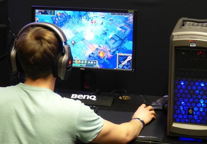 Ein Mann sitzt vor einem Bildschirm und spielt ein Videospiel