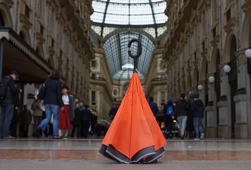 Ein oranger Regenschirm steht in der Mitte einer Einkaufsgalerie auf dem Boden