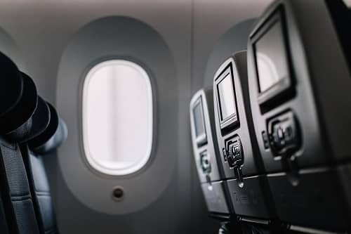 Eine Sitzreihe im Flugzeug und man sieht die Monitore in den Sitzen davor