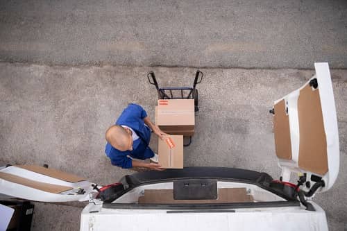 Ein Mann belädt einen Transporter mit Paketen