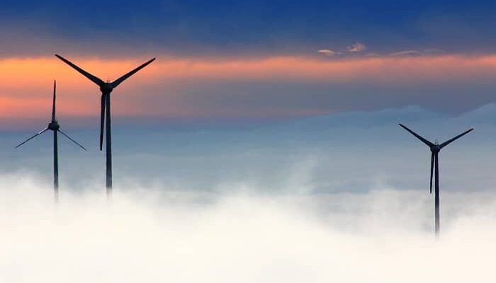 Drei Windräder überragen die Wolken