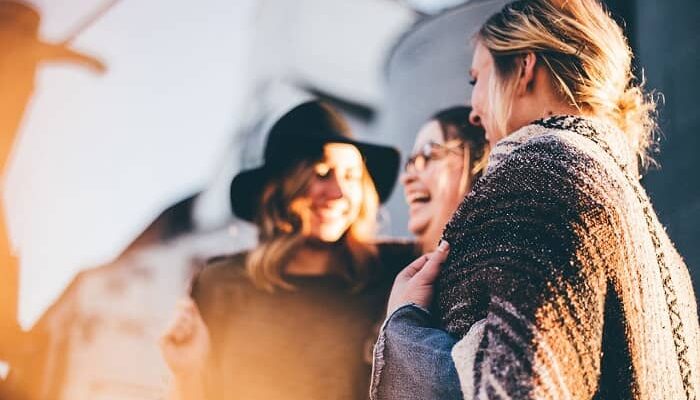 Drei Frauen stehen redend beieinander und lachen