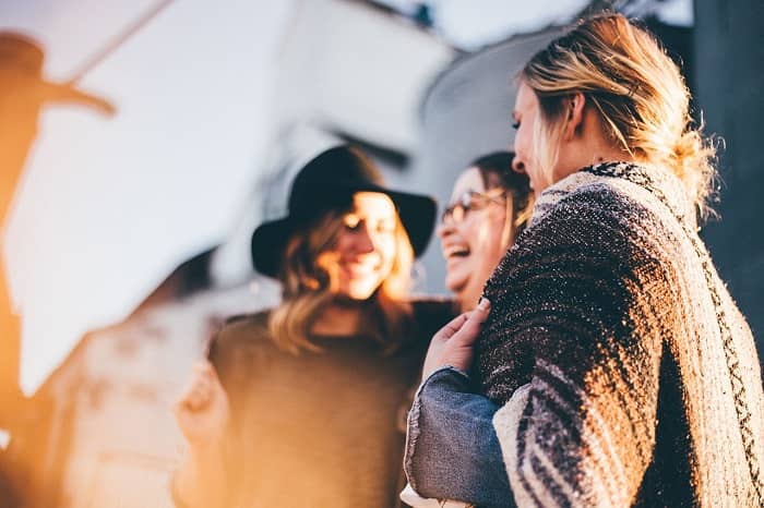 Drei Frauen stehen redend beieinander und lachen