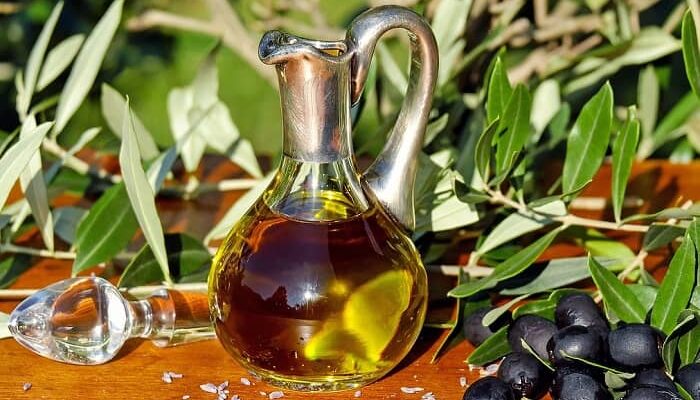 Ein Fläschchen mit Olivenöl steht auf einem Tisch