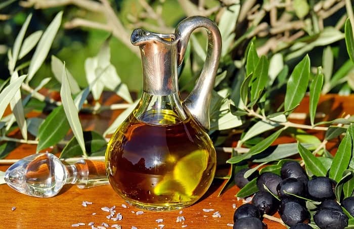 Ein Fläschchen mit Olivenöl steht auf einem Tisch