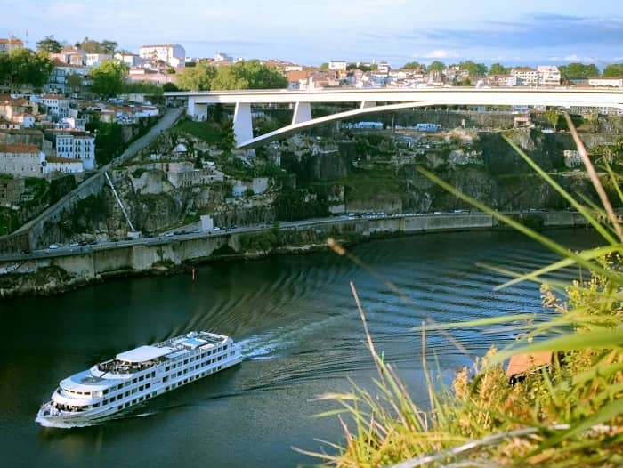 Ein Flusskreuzschiff fährt unter einer Brücke hindurch