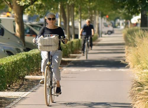 Eine Frau fährt mit dem Fahrrad einen Radweg entlang