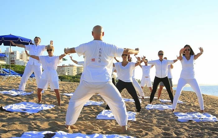 Eine Gruppe von Männer und Frauen machen am Strand Sport