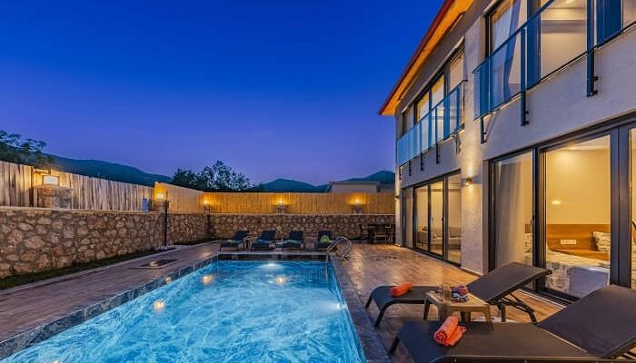 Eine Terrasse bei Nacht, in die ein Swimming Pool eingelassen ist