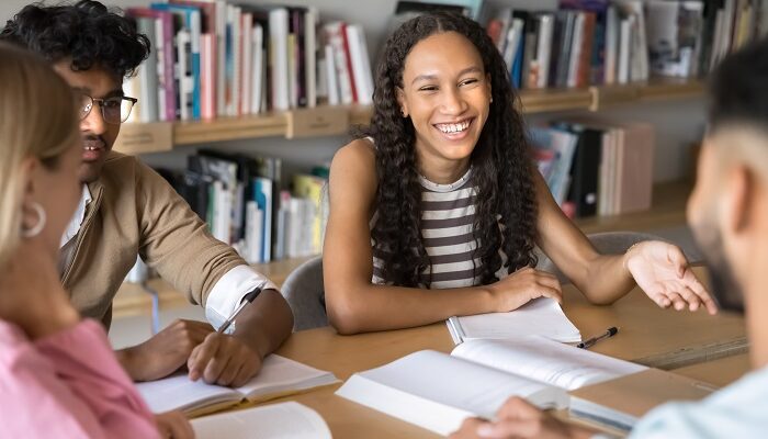 Eine Dreiergruppe Schüler sitzen bei Ihrem Lehrer und lernen