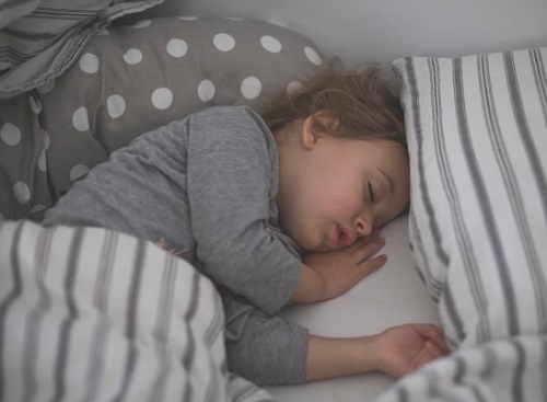 Kind schläft im Bett 