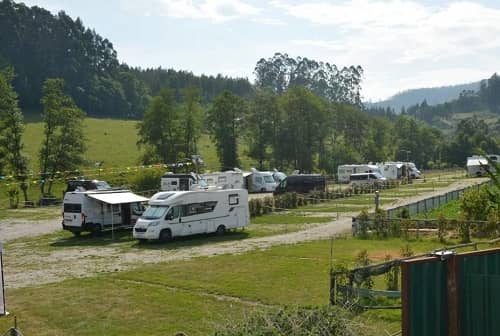 Wohnmobile stehen auf einem Campingplatz in freier Natur
