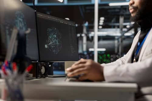 Ein Mann sitzt vor einem Bildschirm und schreibt