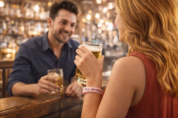 Eine Frau mit dem Single-Bracelet lernt einen Mann in einer Bar kennen.